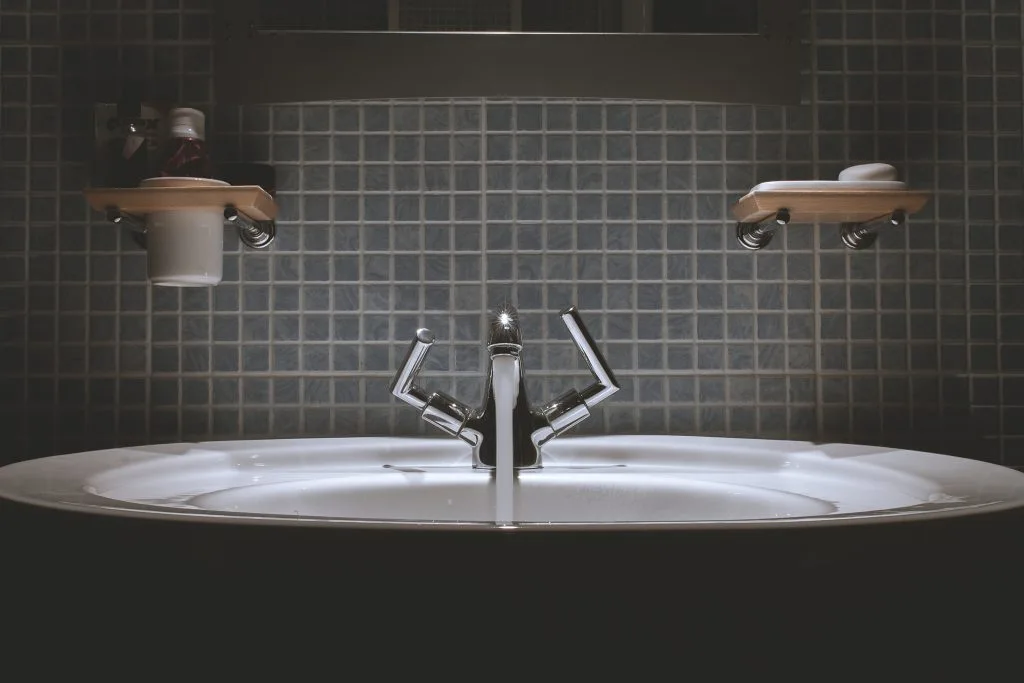 Modern bathroom sink with running faucet, showcasing bathroom design and updated fixtures for a fresh, clean look.