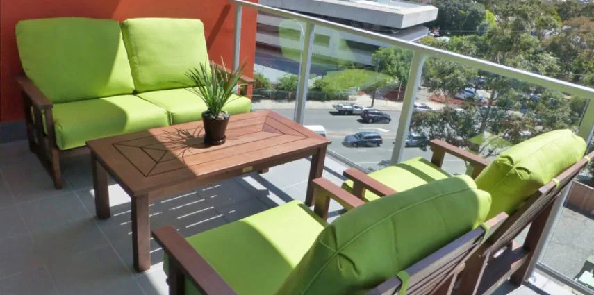 Summer spring patio furniture with green cushions. Outdoor living space ready for spring and summer.